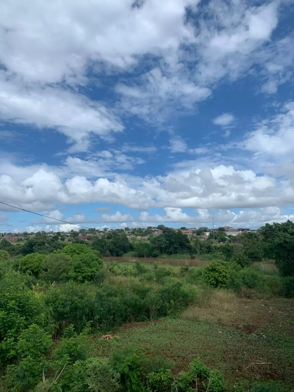 The photo captures a lush green landscape with a river cutti
